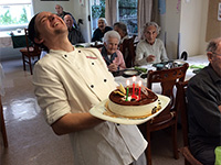 Glenfield Resthome - Laughing chef with birthday cake